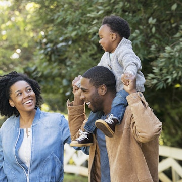 A Black family laughing together in a park