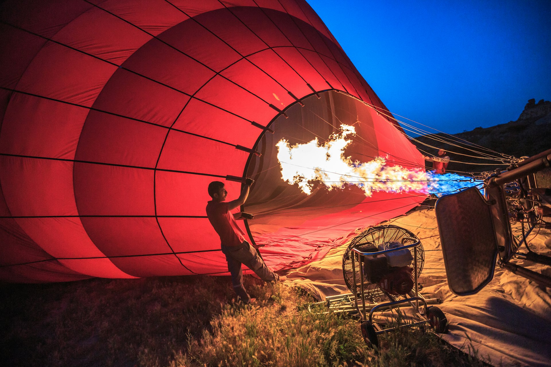 Turkish men inflating a hot air balloon, in preparation for take-off for a dawn flight, at GÃ¶reme, the famous town of fairy chimney and pigeon houses, a UNESCO world heritage site situated in Nevsehir Province, in the Cappadocia Region