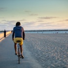 A man riding his bike on Venice Beach, Los Angeles, California at sunset.
996262932