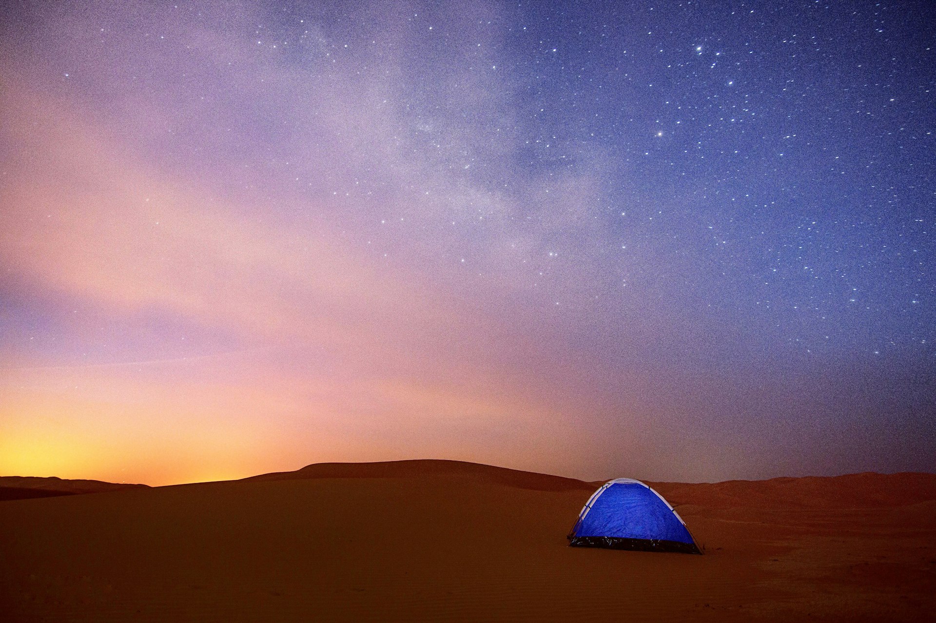 Tent in the desert during sunset in Abu Dhabi with stars in the sky