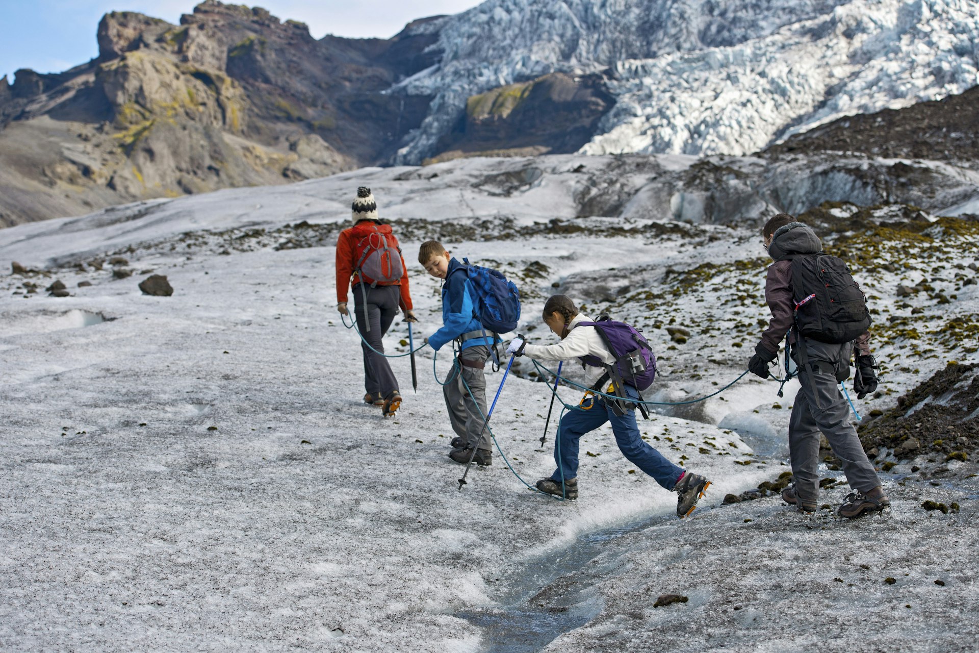 A family walking on a glacier in Iceland together 