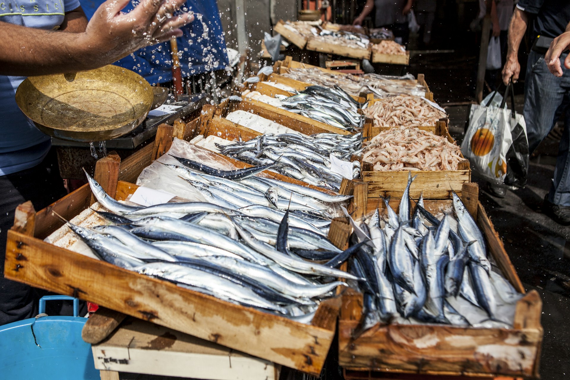 Uma barraca de peixe em La Pescheria, o mercado de peixe de Catânia, com caixas de madeira cheias de vários tipos de peixe fresco