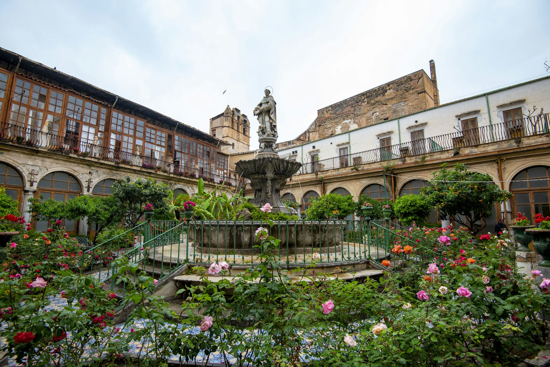 The courtyard of the Chiesa di Santa Caterina d'Alessandria in Palermo, Italy, with blooming flowers.