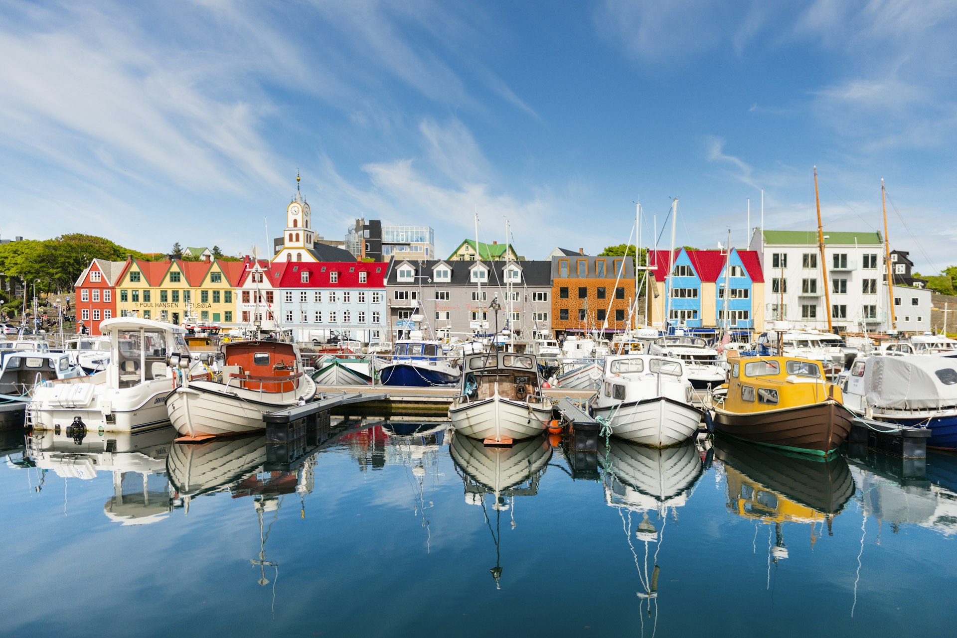 Muitos barcos de pesca estão alinhados em uma fileira de casas coloridas no porto de Tórshavn, nas Ilhas Faroé 