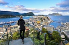 Blond woman enjoying aerial view of the colorful art nouveau town of Alesund Norway
1195943087