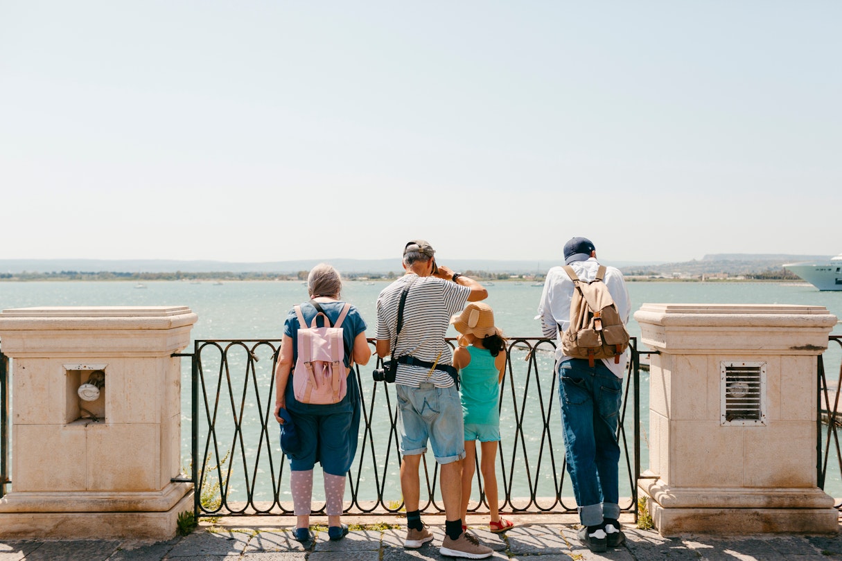Multigenerational group of tourists  standing in front of panoramic view of Mediterranean Sea