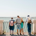 Multigenerational group of tourists  standing in front of panoramic view of Mediterranean Sea