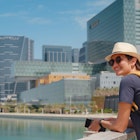 travel to the United Arab Emirates, Happy young asian female traveler in dress and hat look at View of Abu Dhabi Skyline in Al Maryah Island. Vacation and tourist destination concept.; Shutterstock ID 2313143921; GL: 65050; netsuite: Online Editorial; full: Abu Dhabi for free; name: Tasmin Waby
2313143921