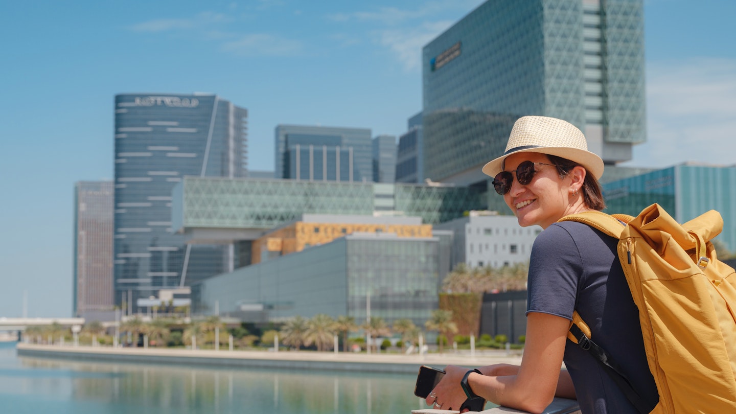 travel to the United Arab Emirates, Happy young asian female traveler in dress and hat look at View of Abu Dhabi Skyline in Al Maryah Island. Vacation and tourist destination concept.; Shutterstock ID 2313143921; GL: 65050; netsuite: Online Editorial; full: Abu Dhabi for free; name: Tasmin Waby
2313143921