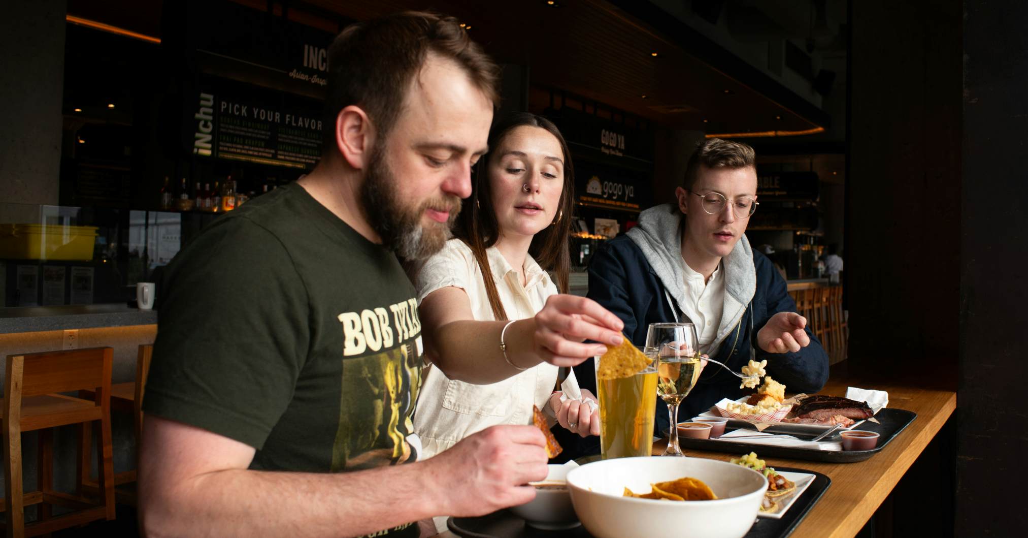 Group of three people eating at a restaurant.