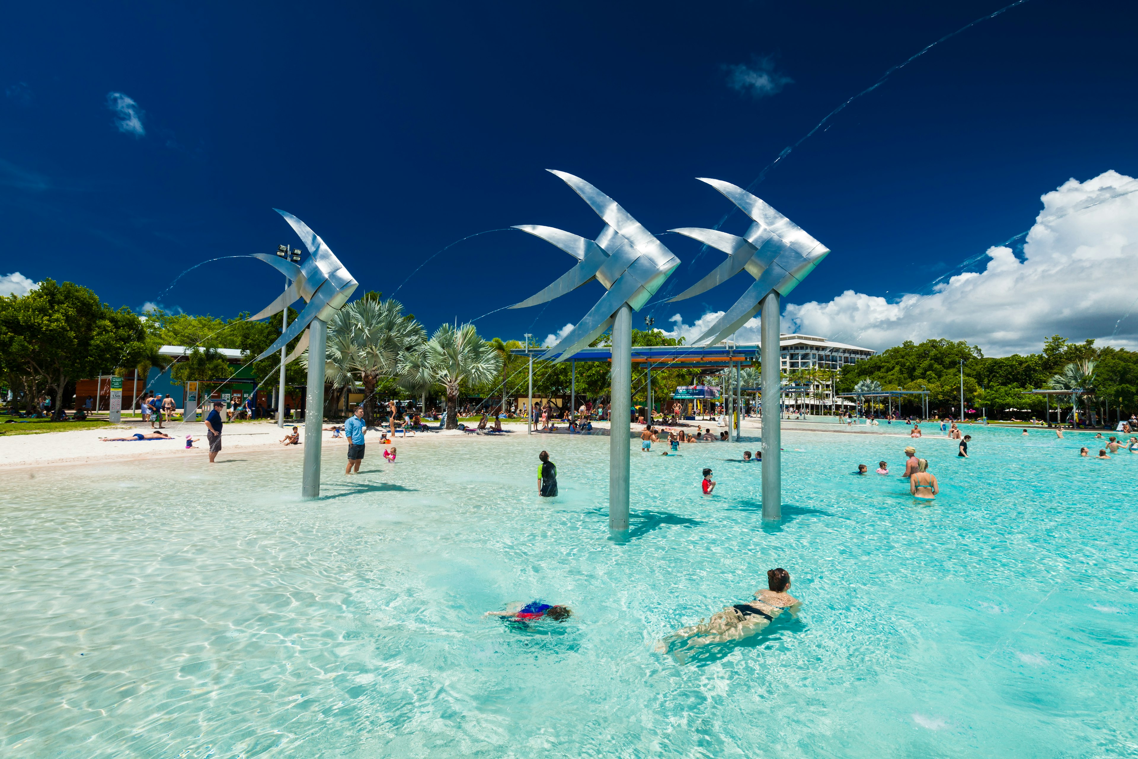 Many people enjoying the crystal clear water of an artificial lagoon in Cairns, in the Far North region of Queensland, Australia