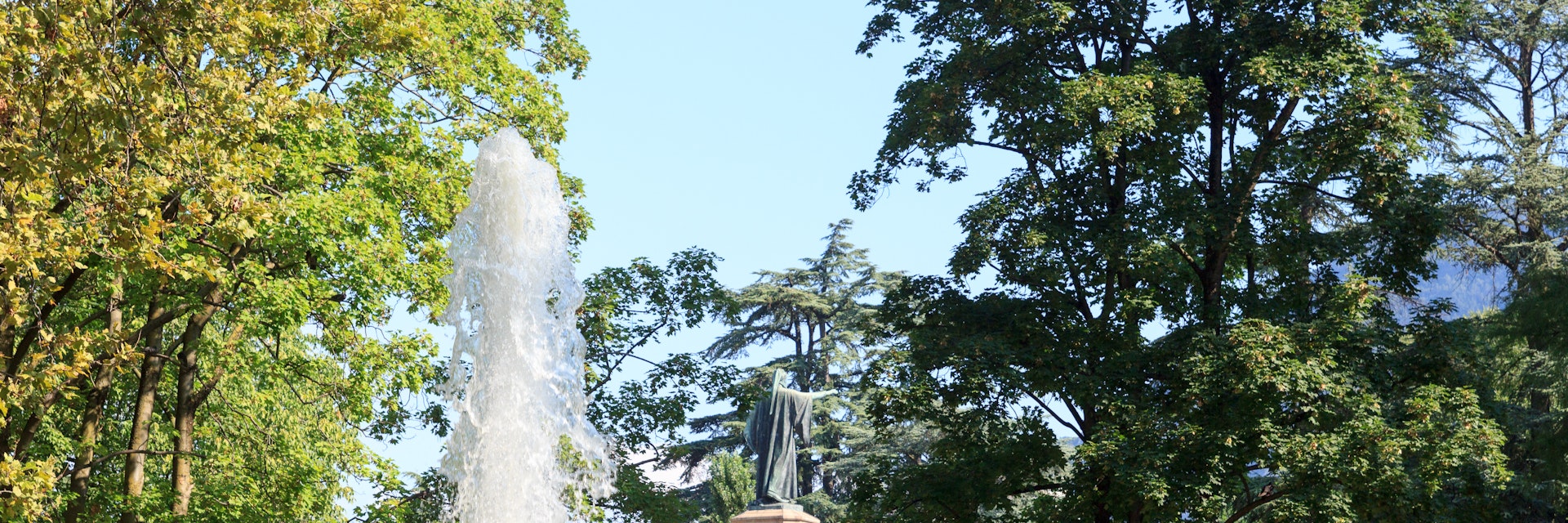 Fountain and monument statue of Dante Alighieri in park Giardini Pubblici in Trento, Italy