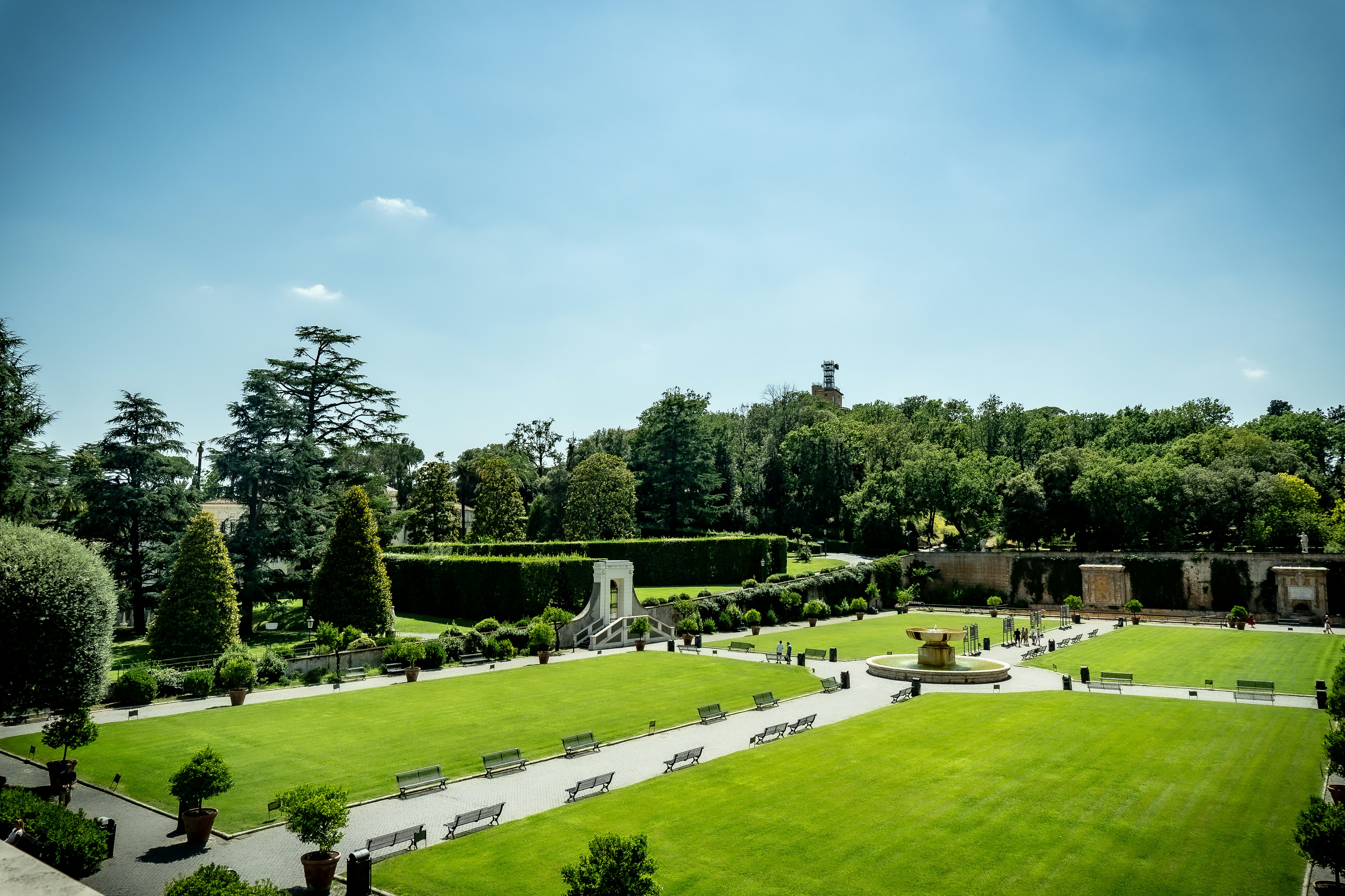 View of Vatican gardens on a sunny summer day. The square garden with green lawn, benches and trees