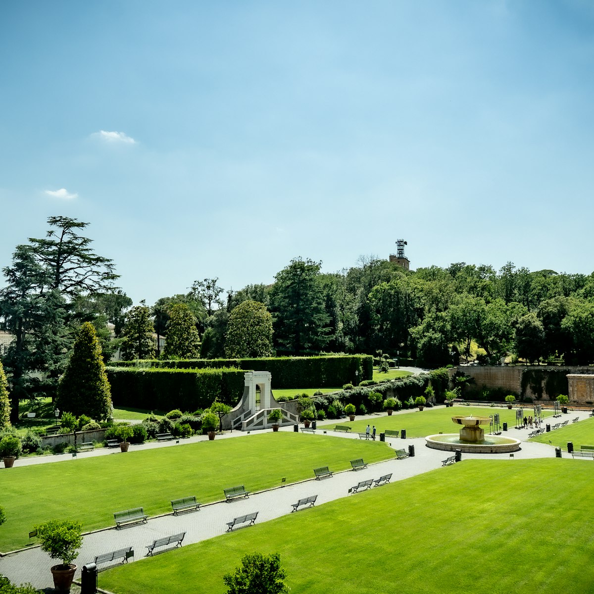 View of Vatican gardens on a sunny summer day. The square garden with green lawn, benches and trees