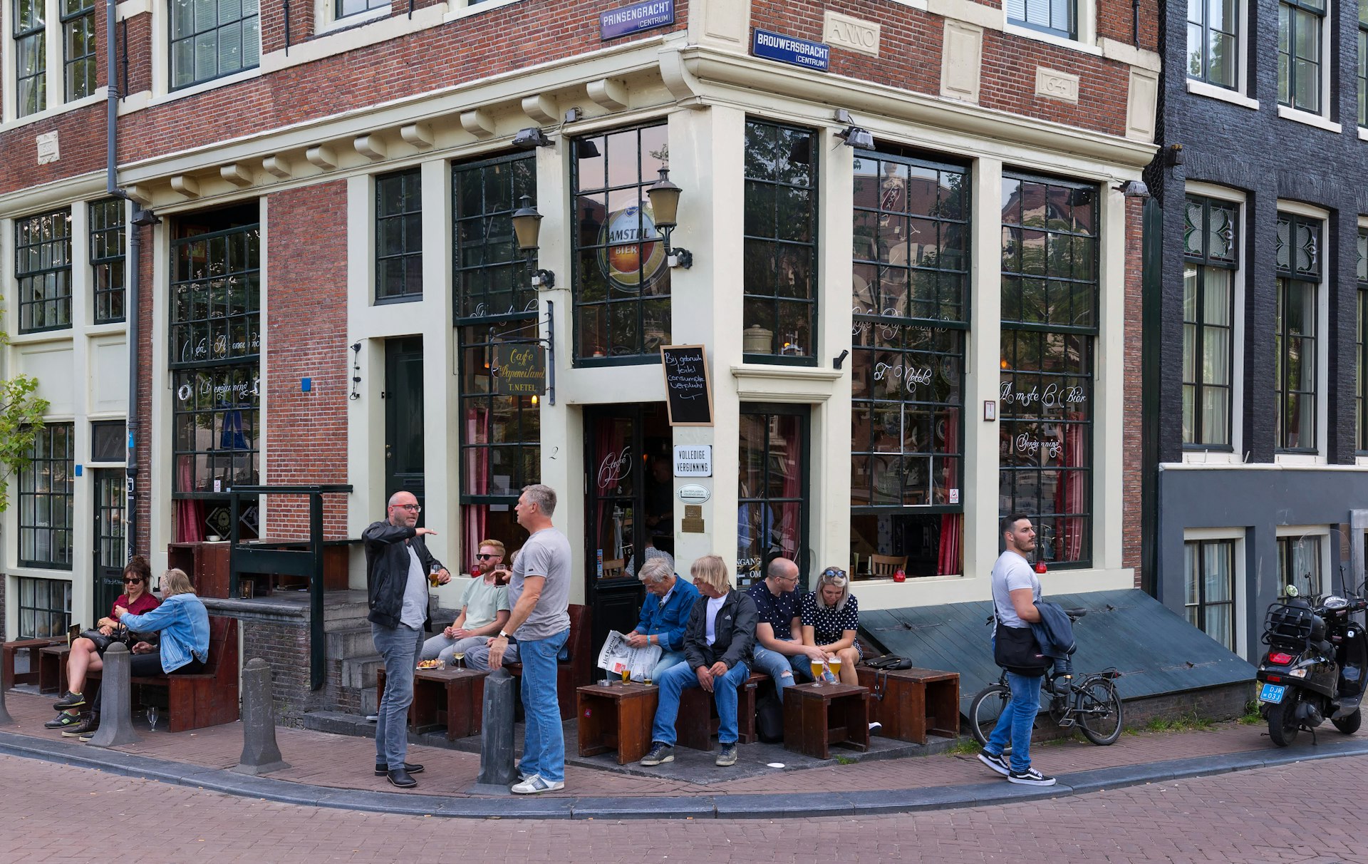 Tourists and local people enjoy the dutch cafe Papeneiland in central Amsterdam, the Netherlands