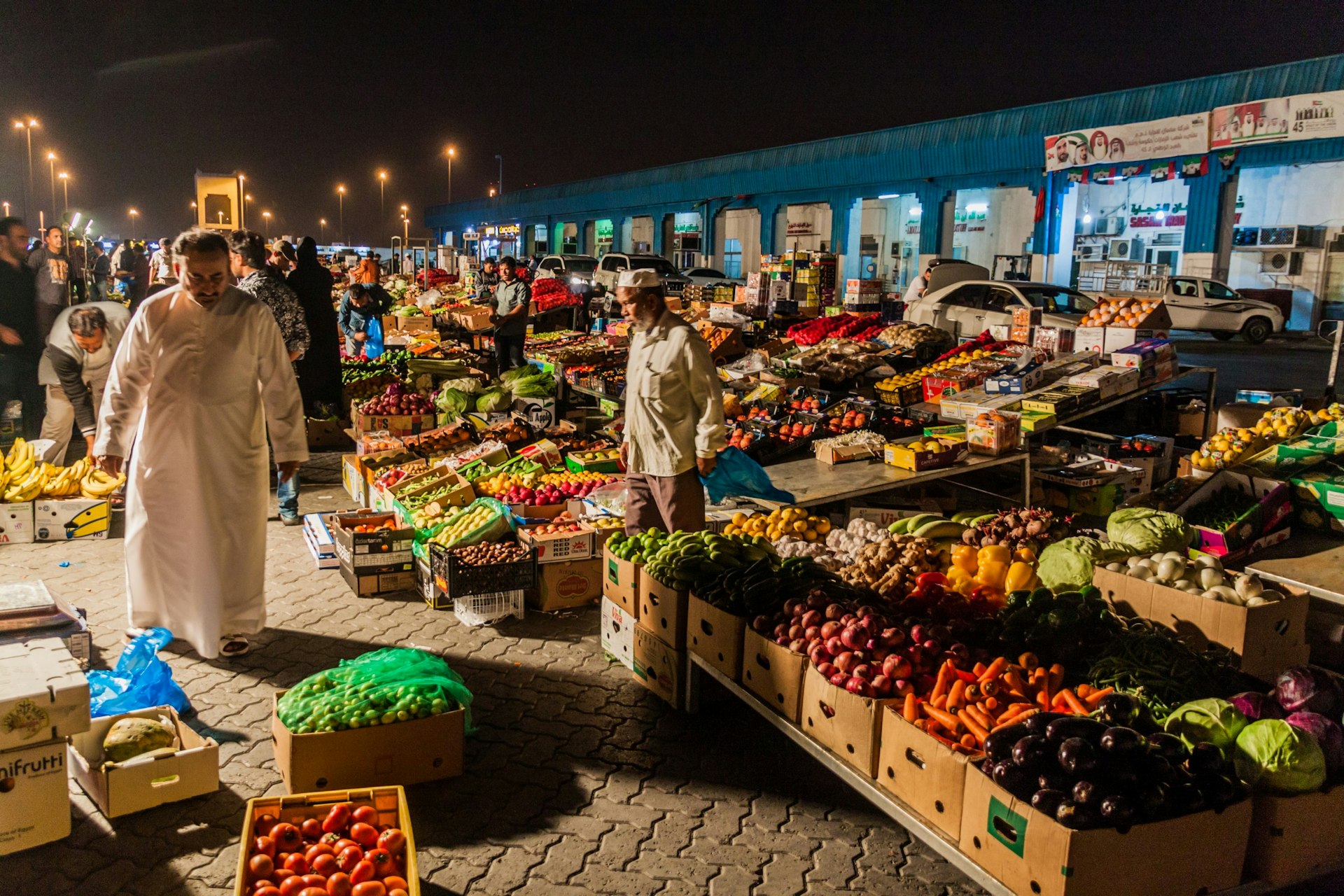 Fruit and vegetables vendors at night at Al Mina market, Abu Dhabi, United Arab Emirates