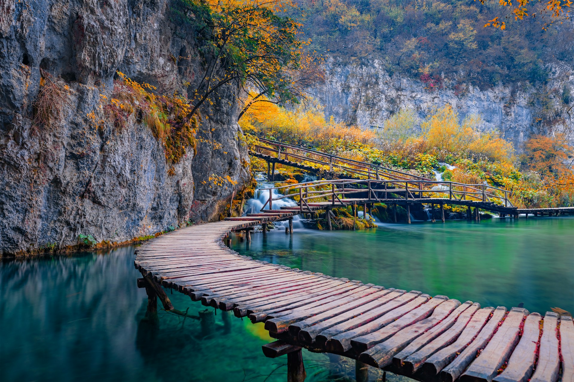 A view of wooden walkway by waterfalls in autumn, Plitvice National Park, Croatia