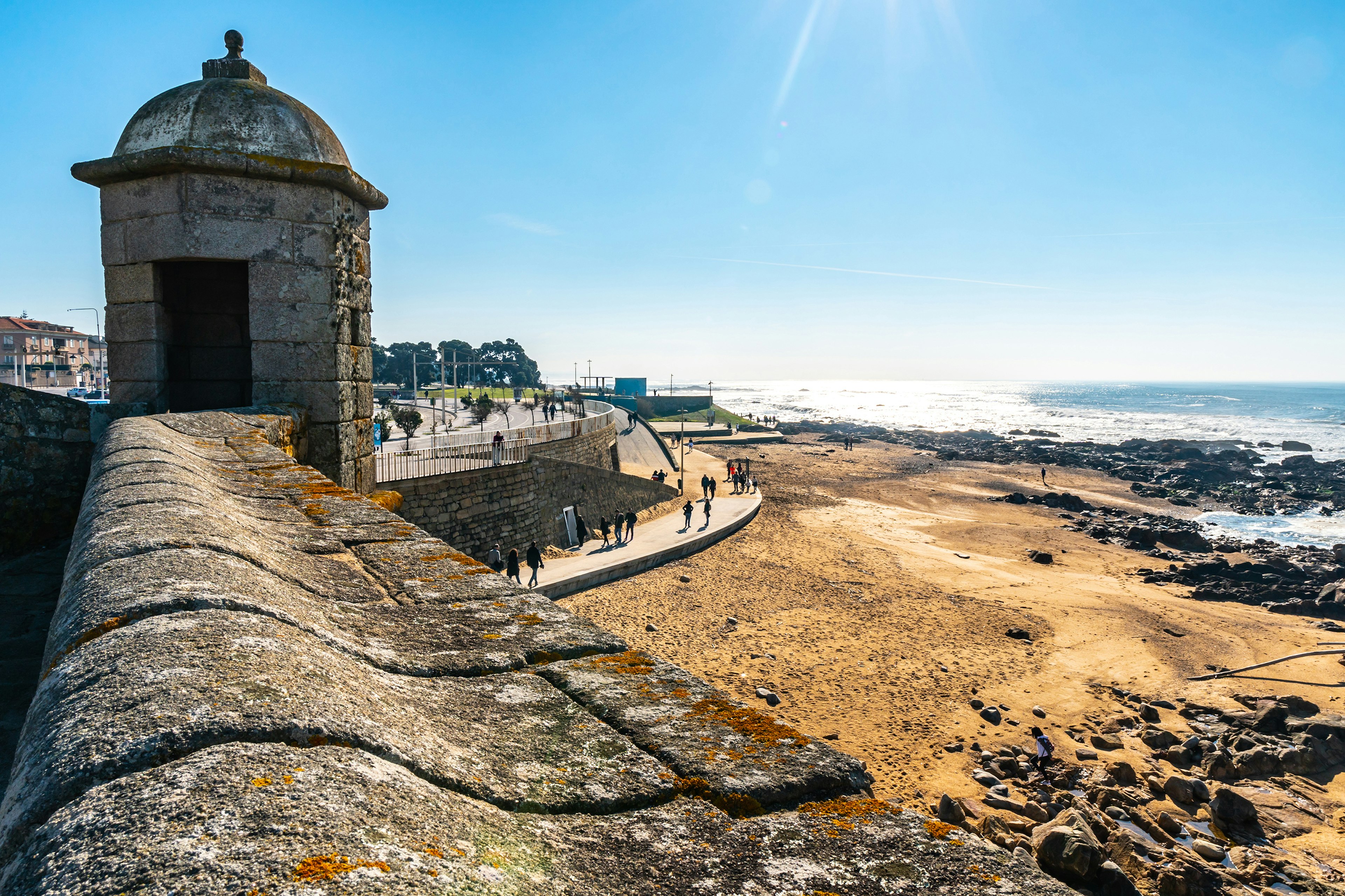 A thick walled fortress dominates a sandy coastline