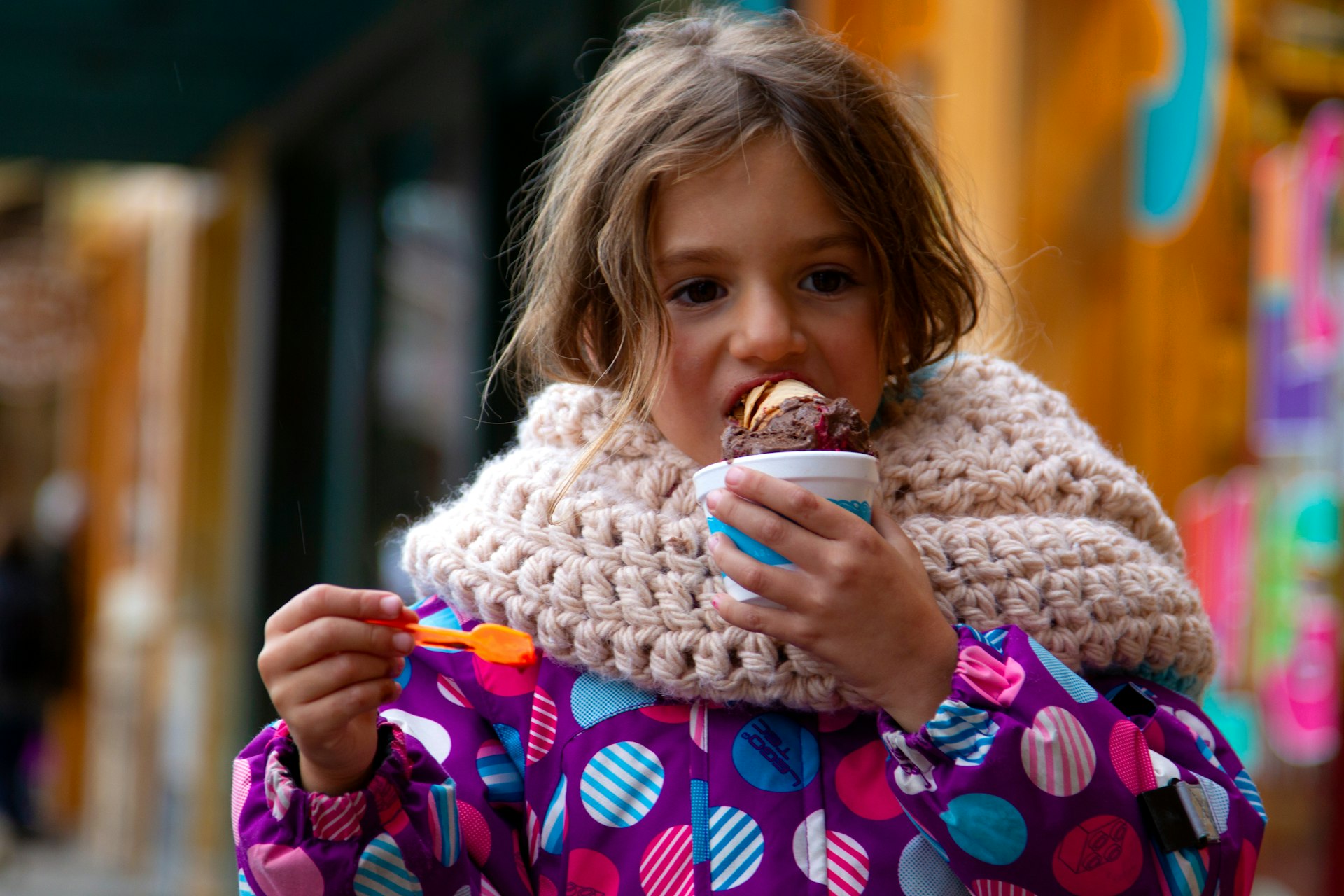 A girl in a knit scarf eats ice cream, Langostura Village, Neuquen, Patagonia, Argentina