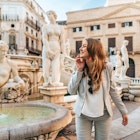 Young woman exploring around in Palermo, beautiful girl standing next to a white fountain in Italy, traveling in Sicily and discovering historical monuments; Shutterstock ID 1675701073; GL: 65050; netsuite: Online Editorial; full: Best time to visit Sicily; name: Bailey Freeman
1675701073