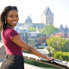 A young black woman smiling to camera with Québec City in the background
