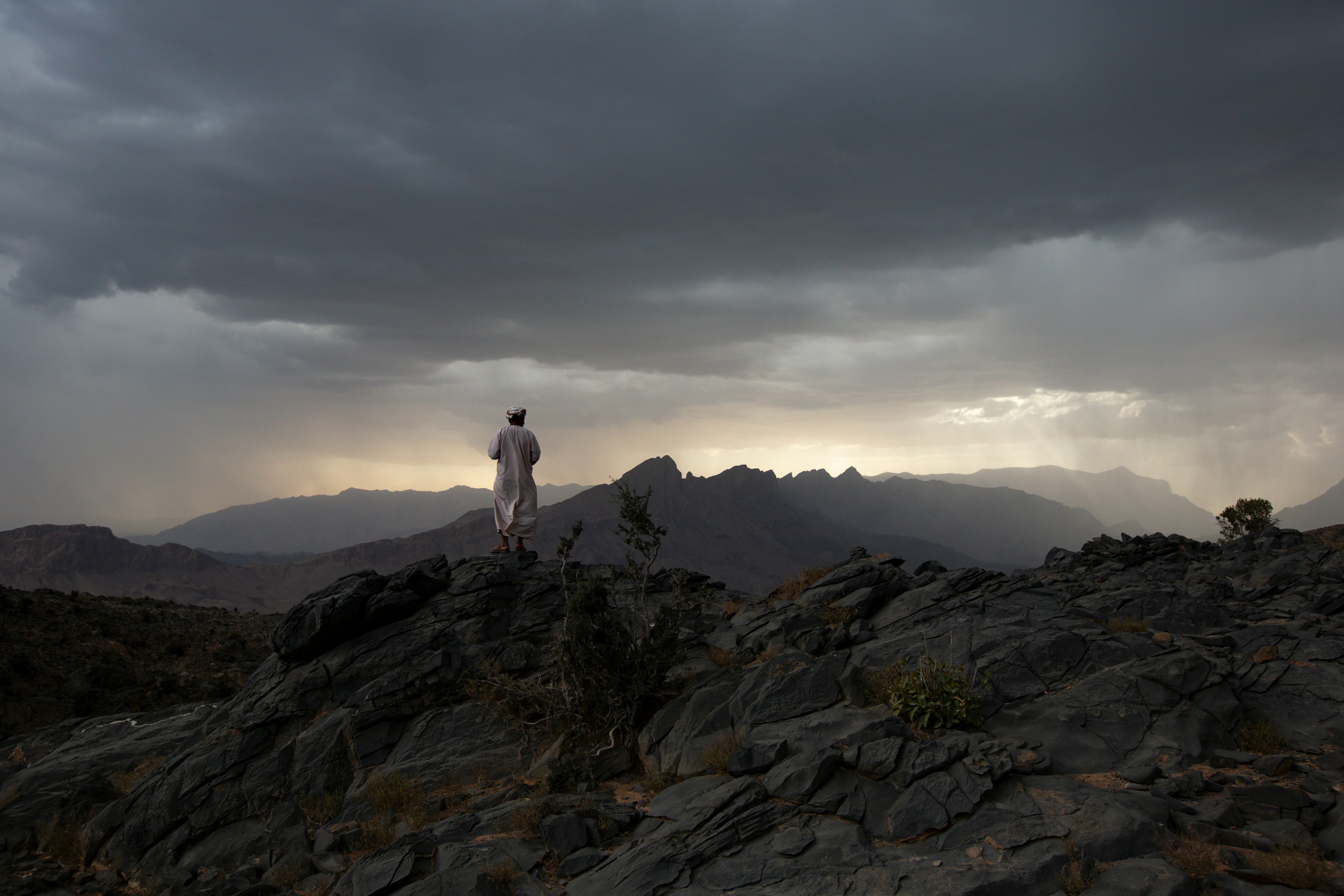 A man explores the mountains during a storm, Al Hamra, Oman