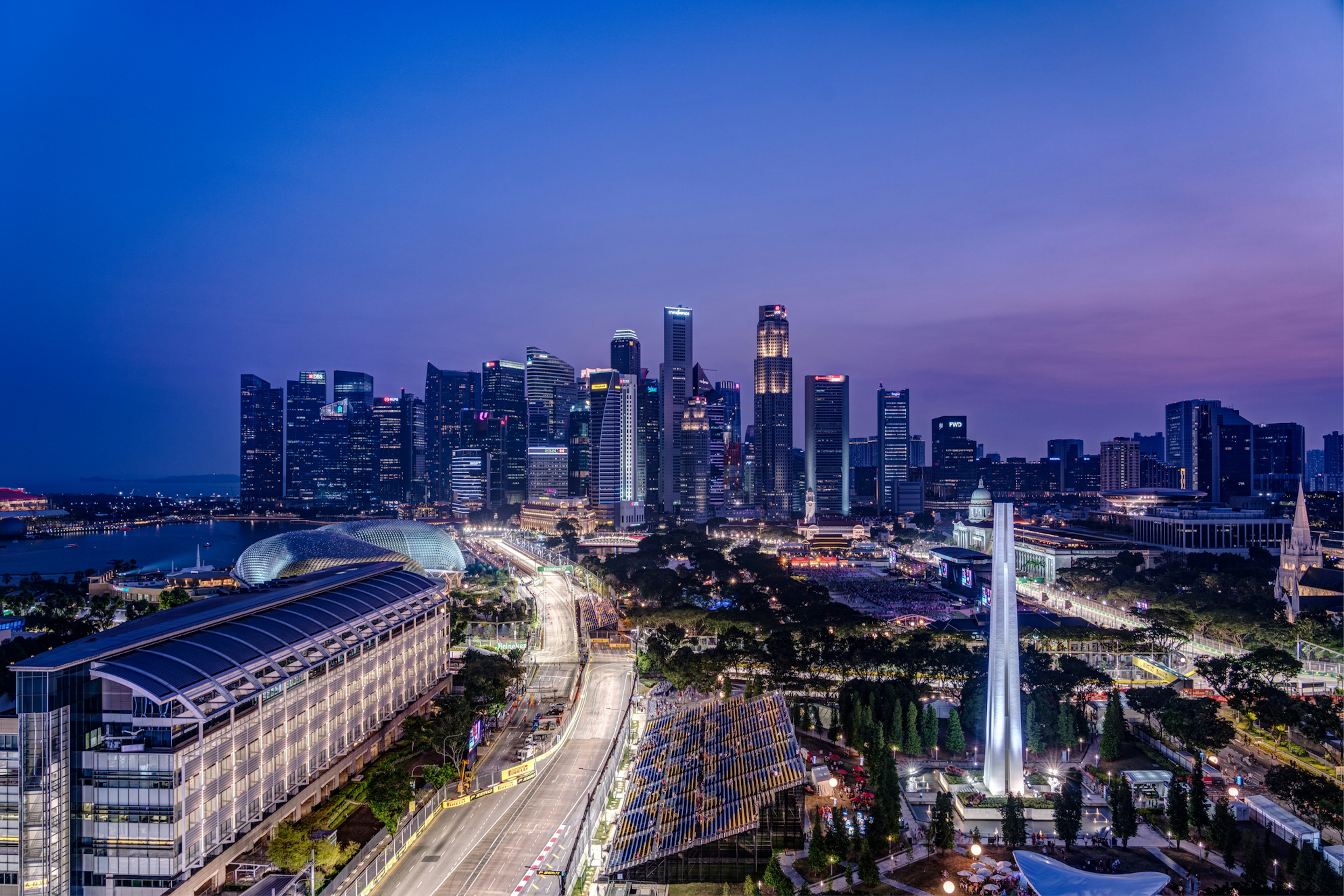 A race track cuts through the center of a built-up city at night