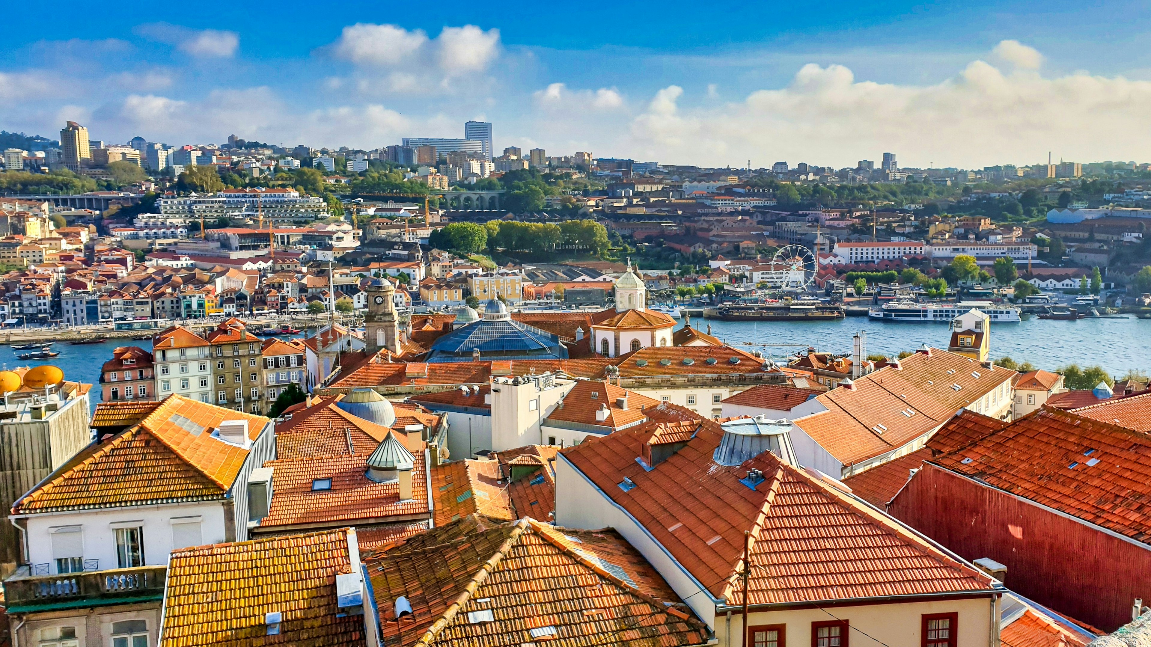 A viewpoint over a city with many red roofed buildings and a river running through the center