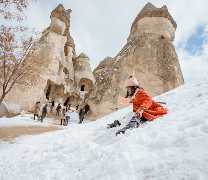happy little girl in red sliding on a pile of snow in pasabag valley cappadocia; Shutterstock ID 2188765535; GL: 65050 ; netsuite: Online Editorial; full: Cappadocia articles; name: Tasmin Waby
2188765535