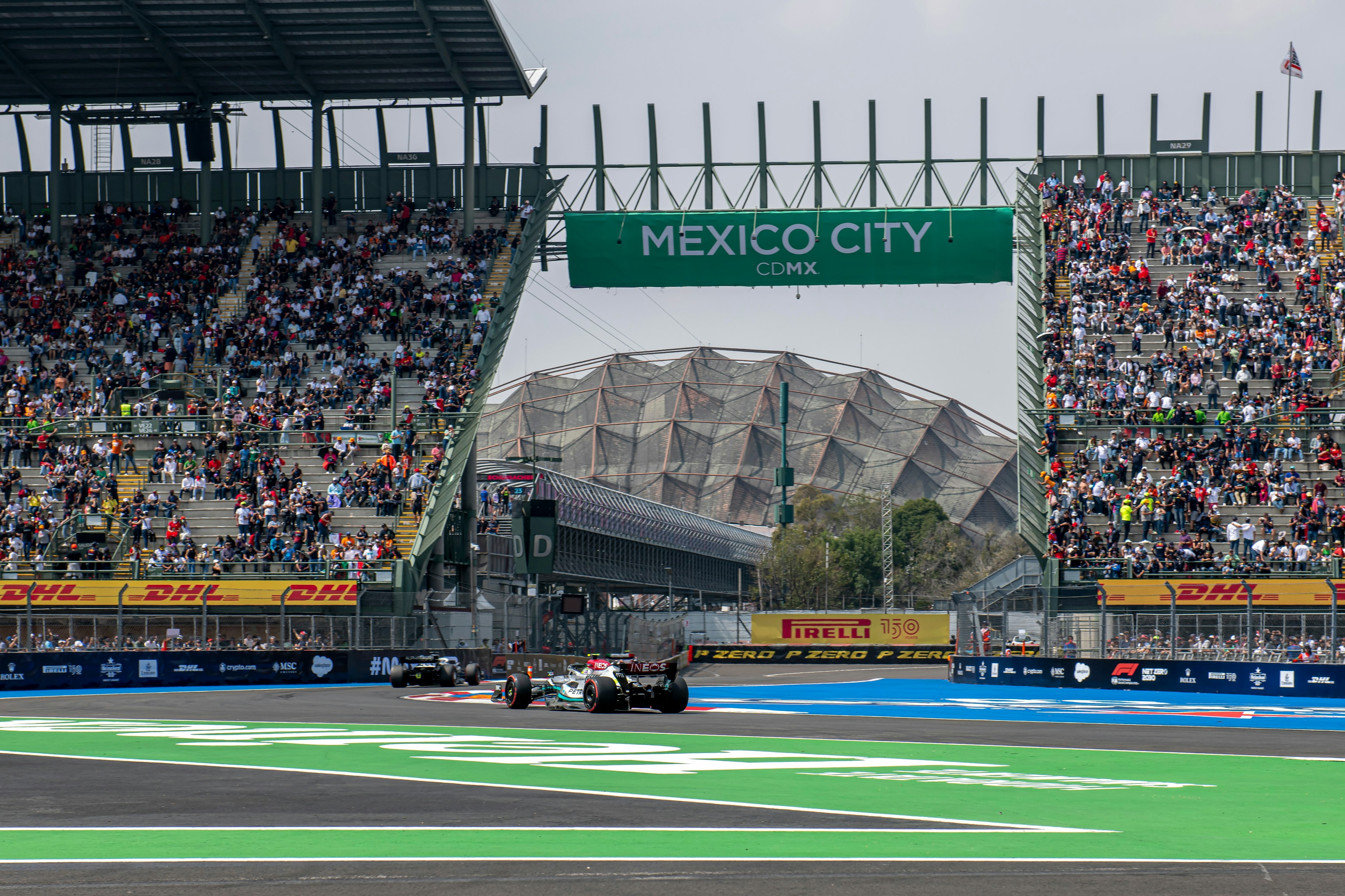 An F1 car on a track in front of huge crowds. The sign above reads "Mexico City CDMX"