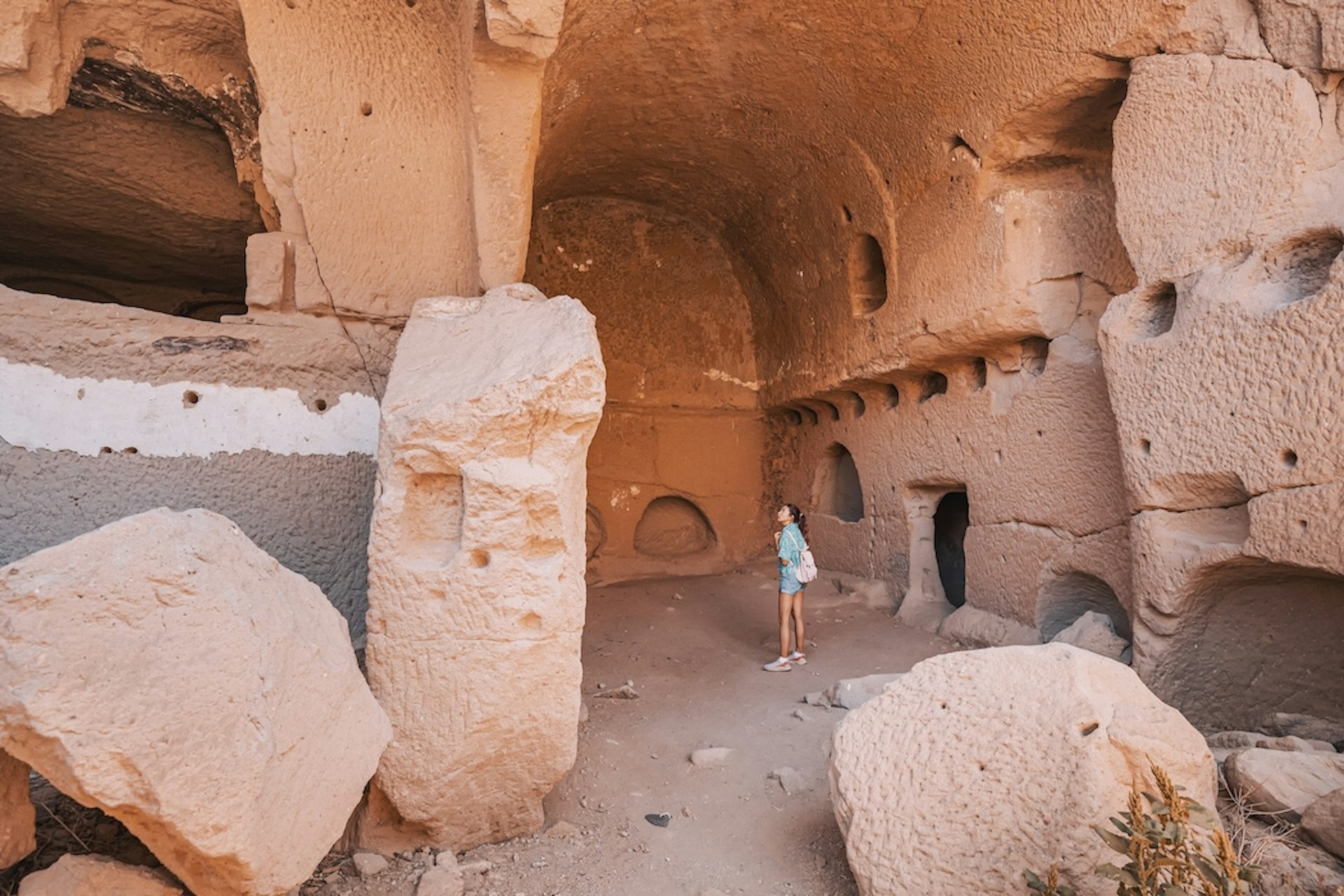 A young woman exploring an ancient cave church in Ihlara valley, Cappadocia, Turkiye