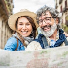 Married couple of tourists sightseeing city street with map - Happy husband and wife enjoying summer vacation together - Touristic life style concept with aged woman and man traveling European city; Shutterstock ID 2289527517; GL: 65050; netsuite: Online Editorial; full: Rome Neighbourhoods; name: Tasmin Waby
2289527517