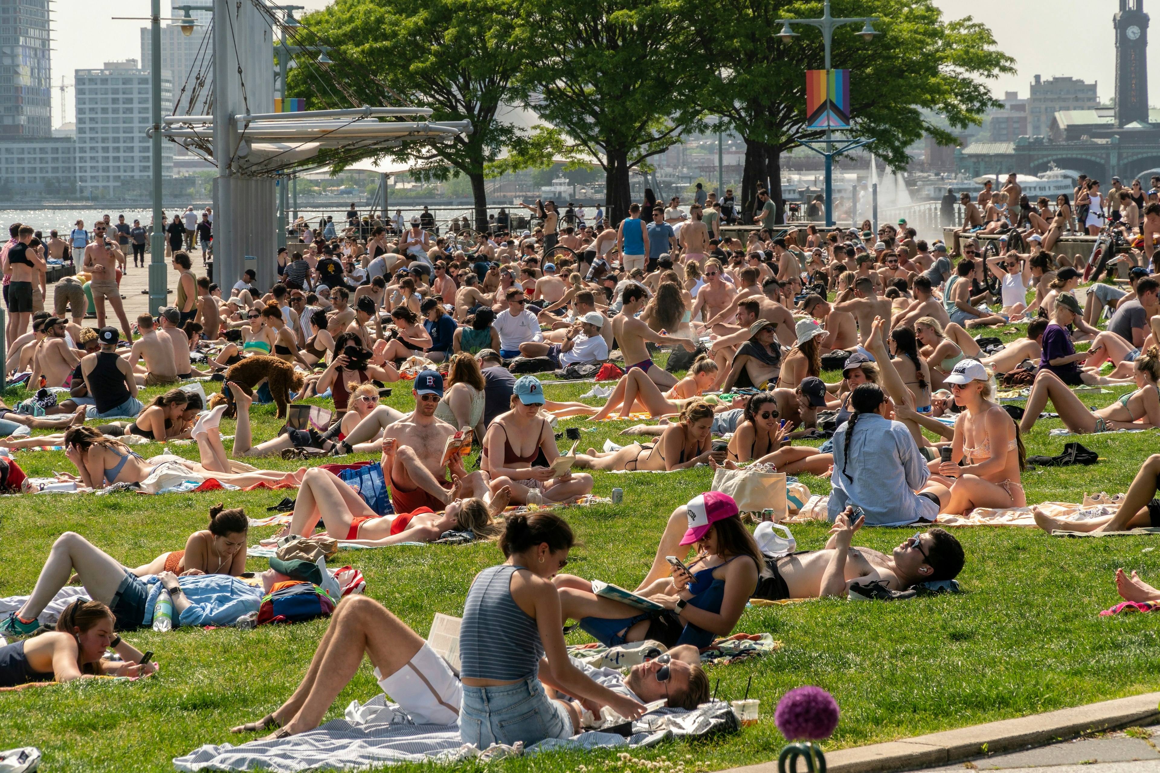 People lie out in the sun on the Christopher Street Pier, West Village, New York City, New York, USA