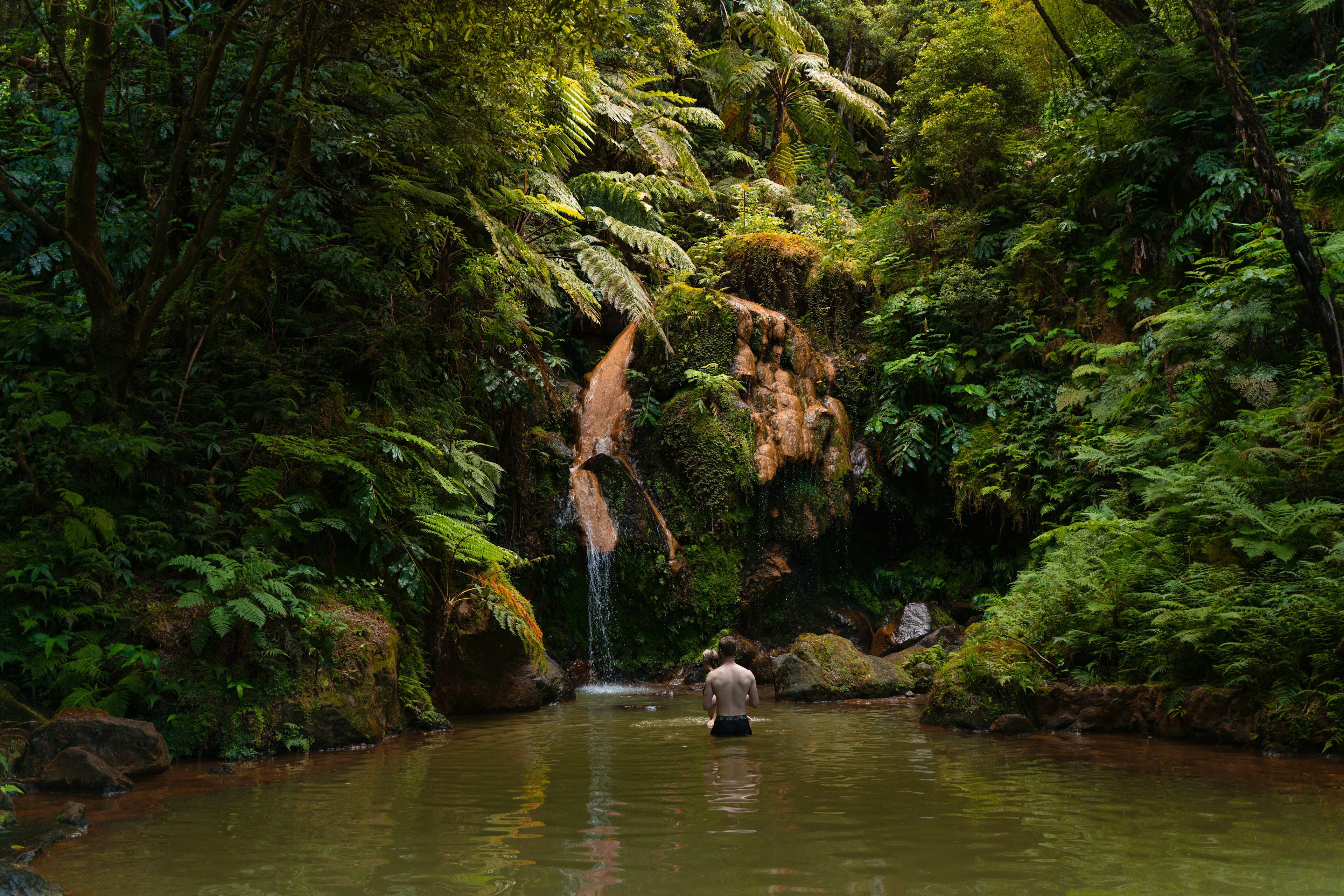 A man swims in the thermally heated pools at Caldeira Velha, São Miguel, Azores, Portugal