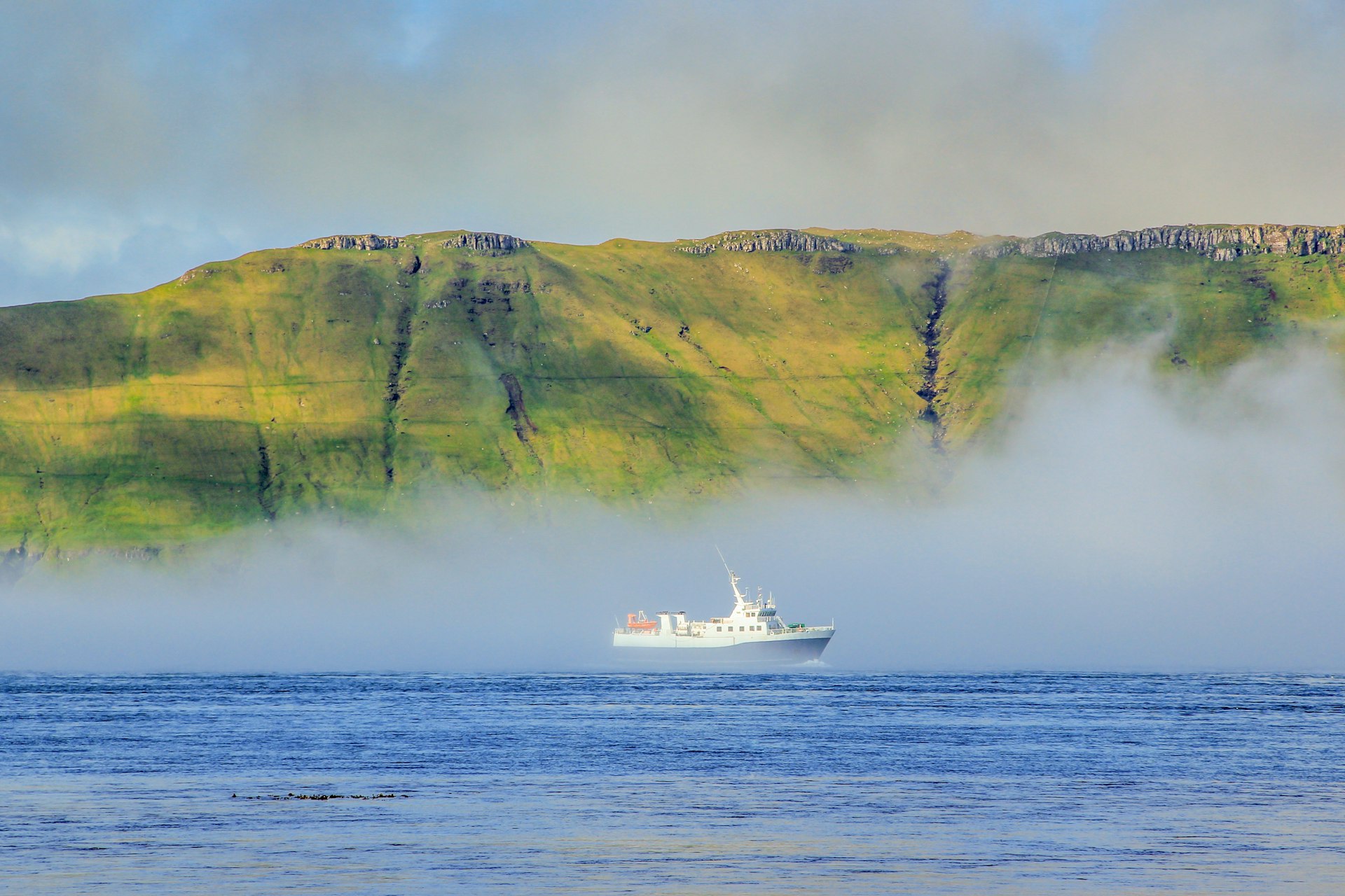 A ferry emerges from the sea fog in the Faroe Islands