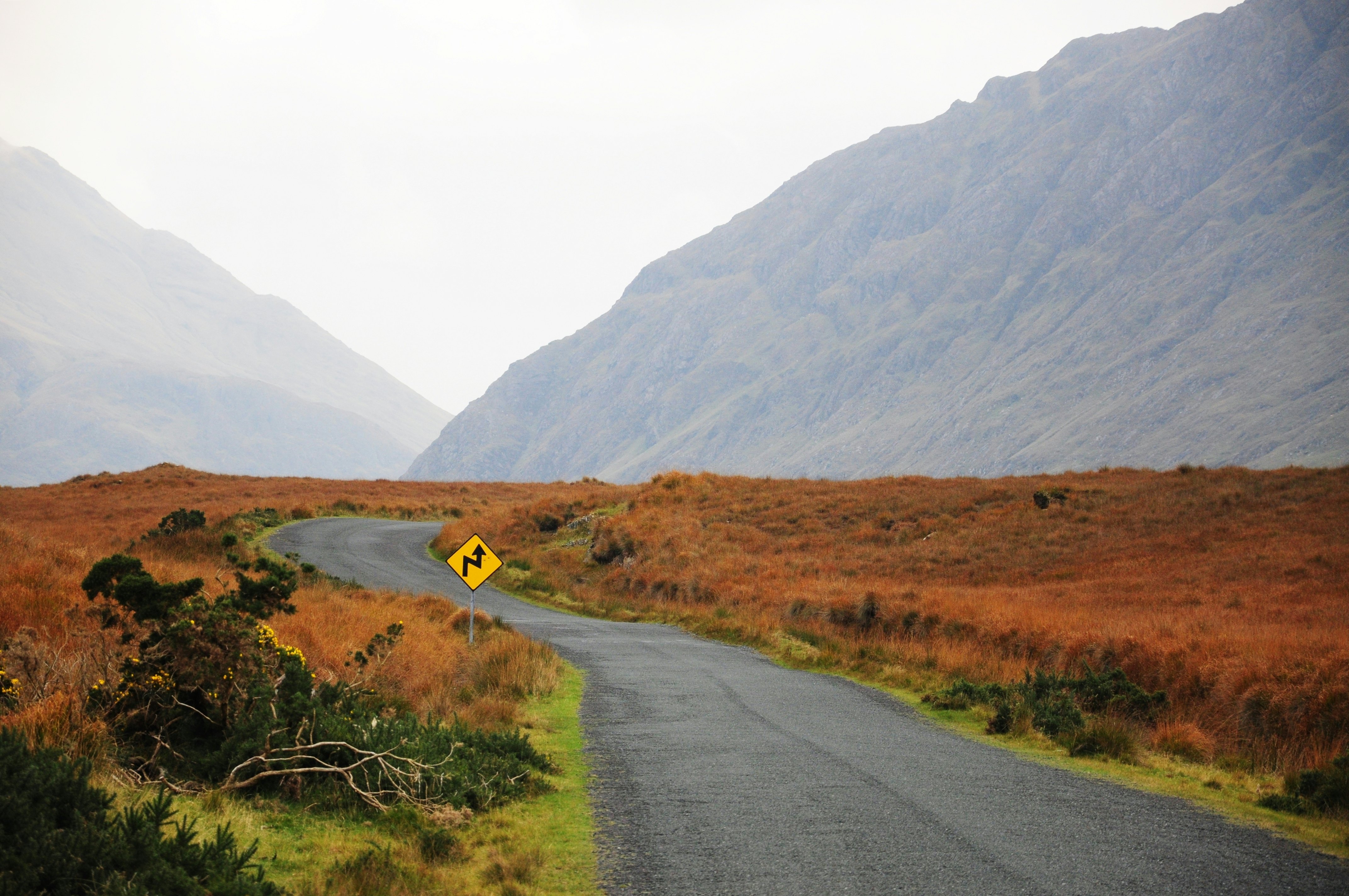 An empty road with foggy mountains in the distance, Mayo, Ireland