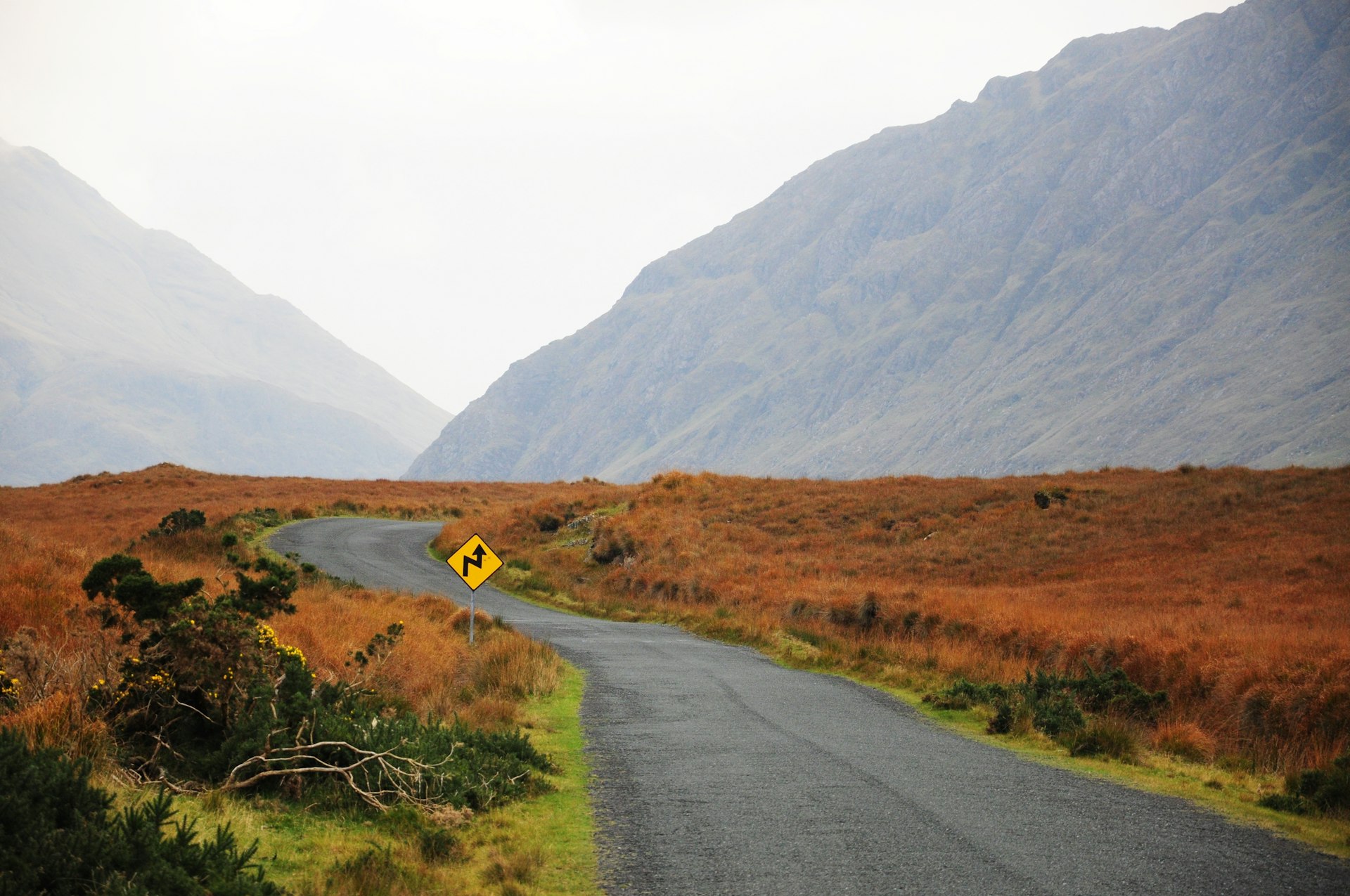 An empty road with foggy mountains in the distance, Mayo, Ireland