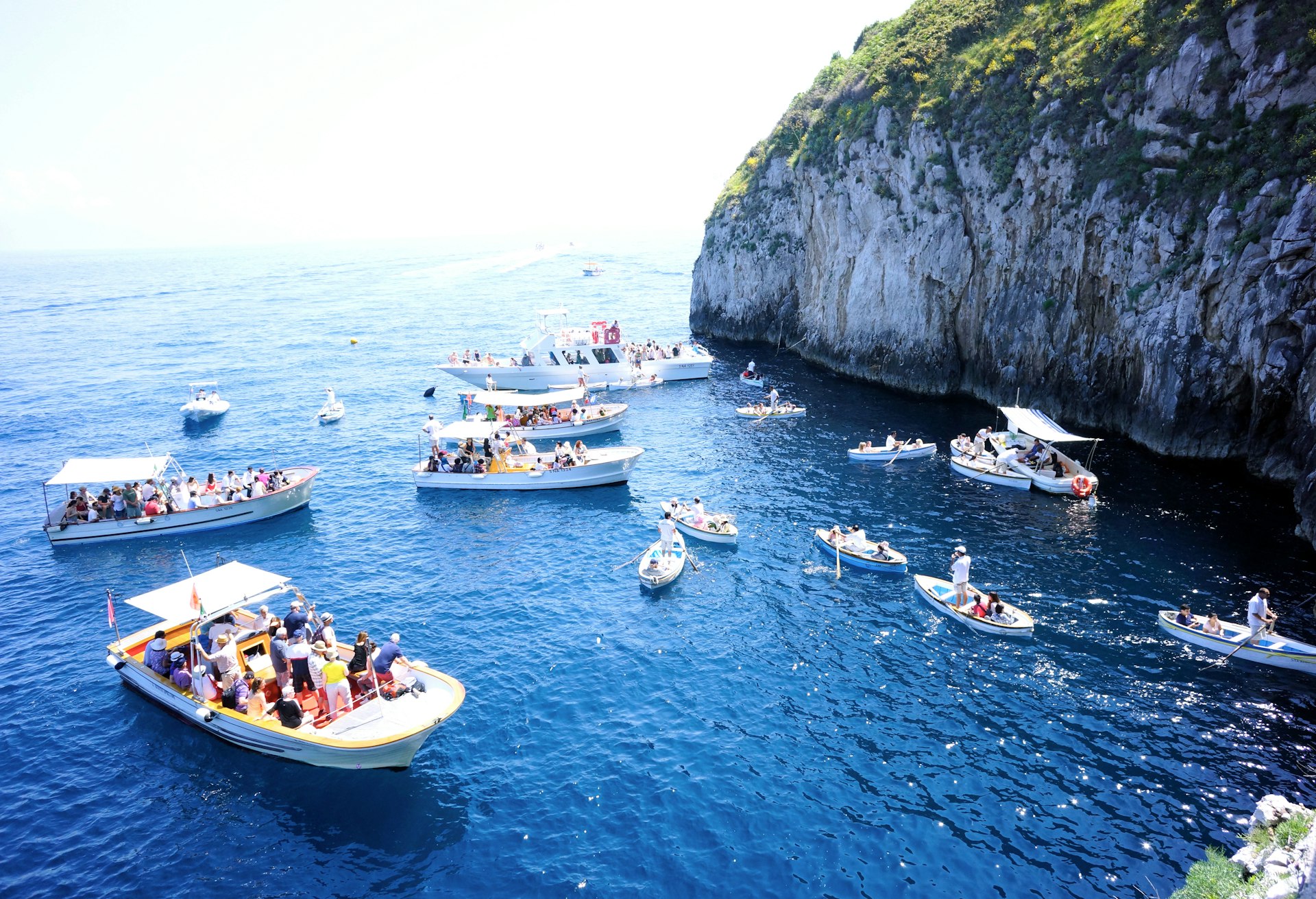 Boats in the water outside the entrance to Grotto Azzurro, Capri, Italy