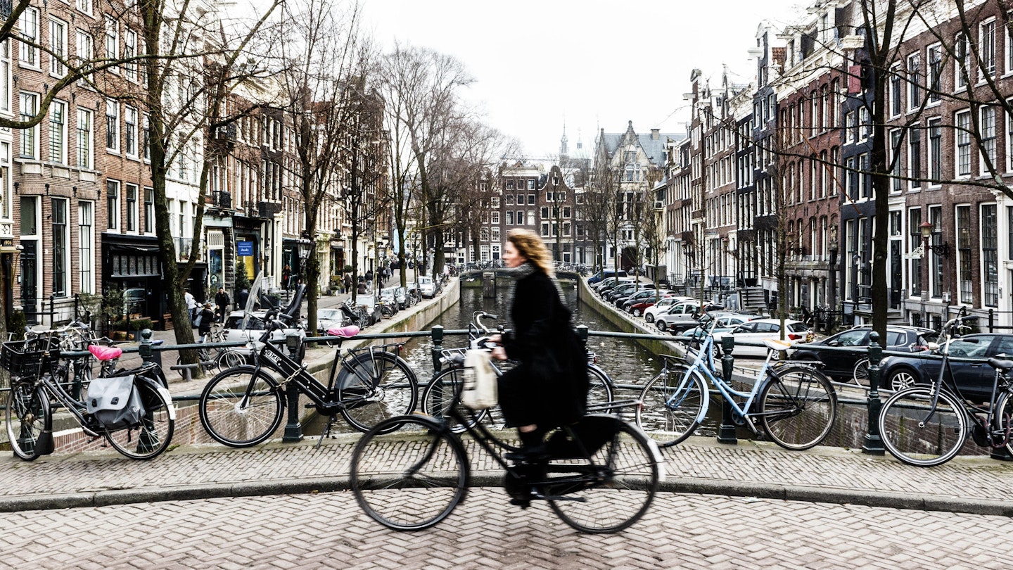 Amsterdam Cyclist traveling over a bridge.; Shutterstock ID 596120624; GL: 65050; netsuite: Lonely Planet Online Editorial; full: Best things in Amsterdam; name: Brian Healy
596120624
amsterdam, bicycle, bike, biking, blue, bridge, canal, city, culture, cycle, cyclist, dutch, europe, holland, man, netherlands, people, person, rain, ride, sky, tourism, traffic, transportation, travel, urban, women