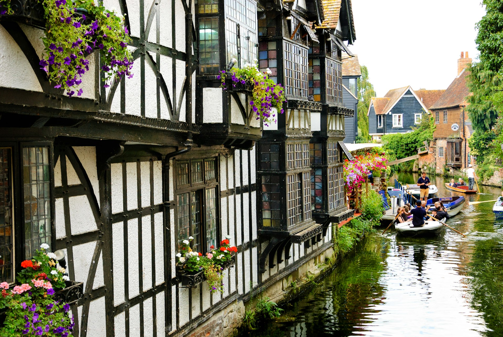 Turistas aproveitando o passeio de barco no coração da antiga Canterbury, Kent, Inglaterra, Reino Unido