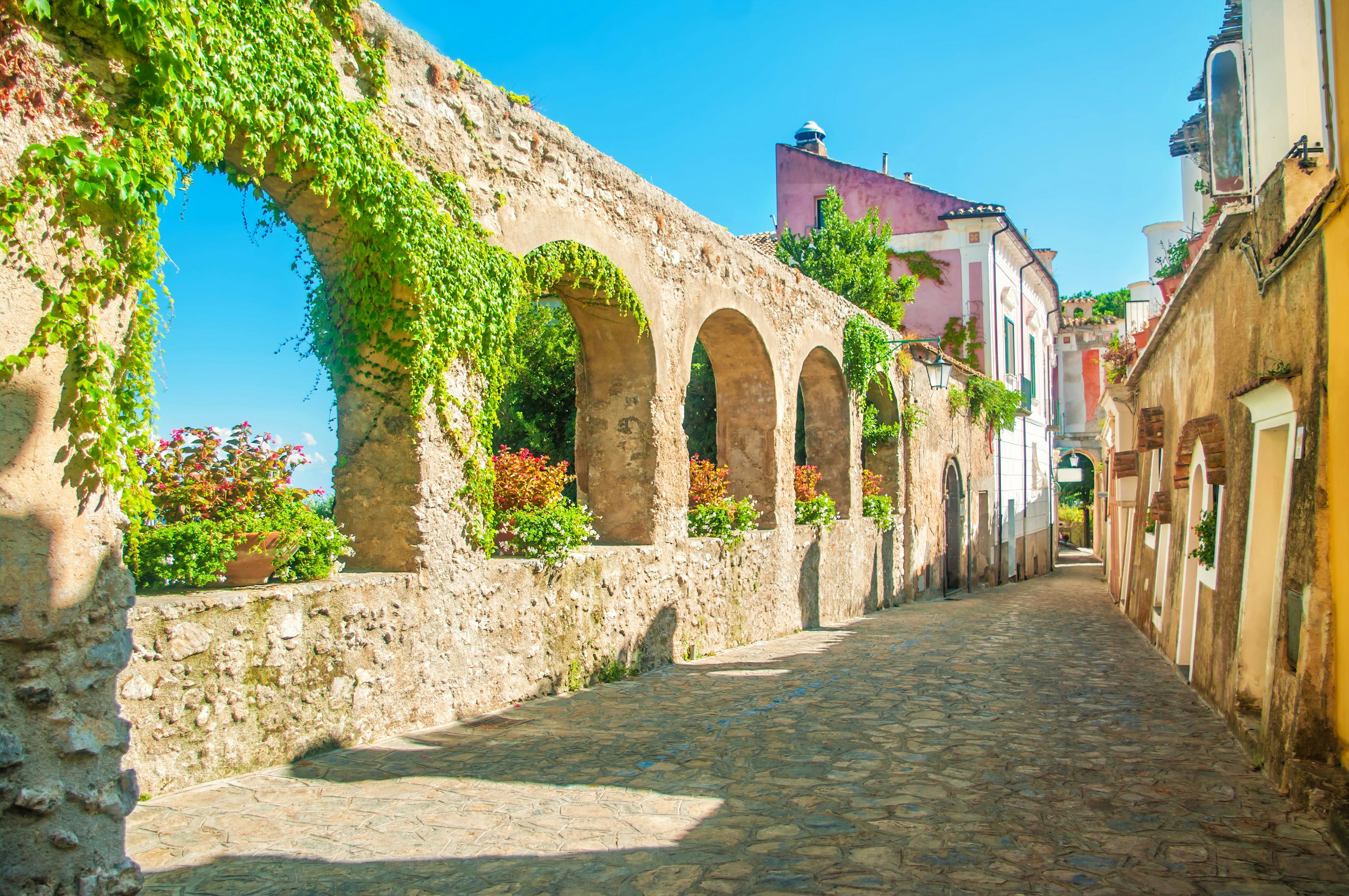 A series of stone archways runs alongside a road