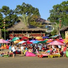 August 14, 2018: A crowd of people under colourful umbrellas outside La Plancha Beach Bar & Restaurant.
1159268683
asia, bali, building, busy, colorful, crowd, famous, kuta, outdoor, people, seminyak, tourism, vacation, beach, kuta beach, indonesia, tourist, holiday, asian, fun, travel, beach party, party, summer, summertime, tourists, sun, bathing, sunbathing, celebration, festival