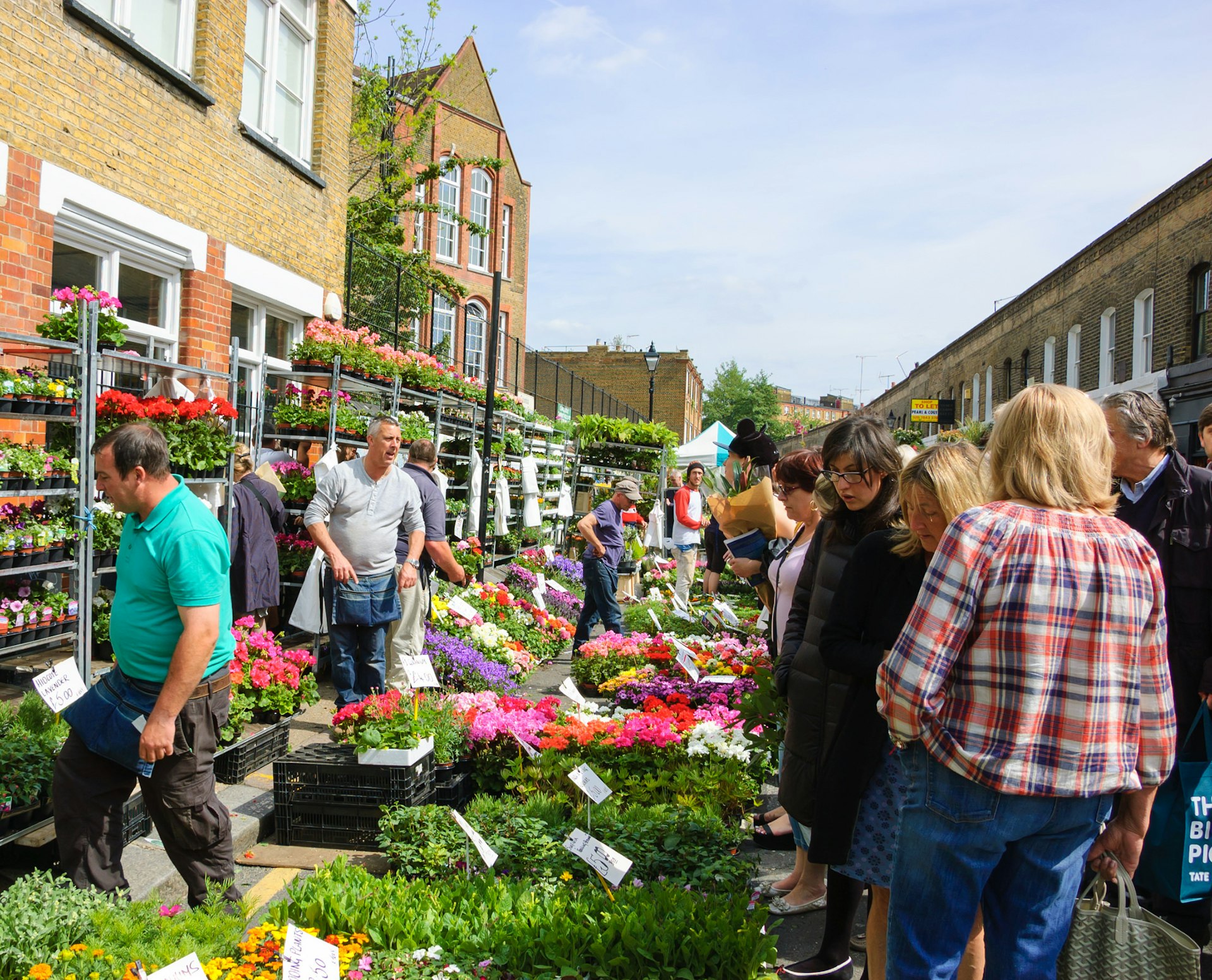 People buying flowers at Columbia Road Flower Market. This London's principal flower market is opened every Sunday.