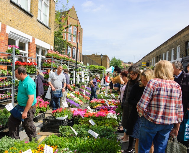 People buying flowers at Columbia Road Flower Market. This London's principal flower market is opened every Sunday.