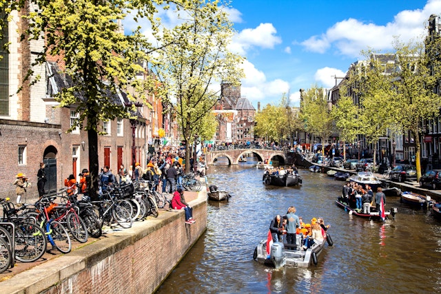 Streets and Canals of Amsterdam full of people dressed in orange celebrating King's day on April 27, 2015 in Amsterdam,