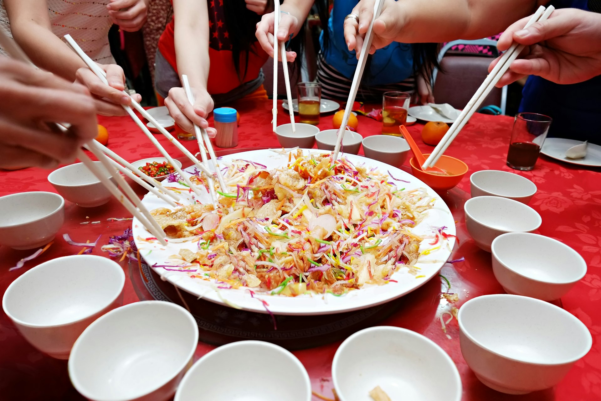 Bowls, chopsticks and eager diners about to eat a traditional Chinese meal