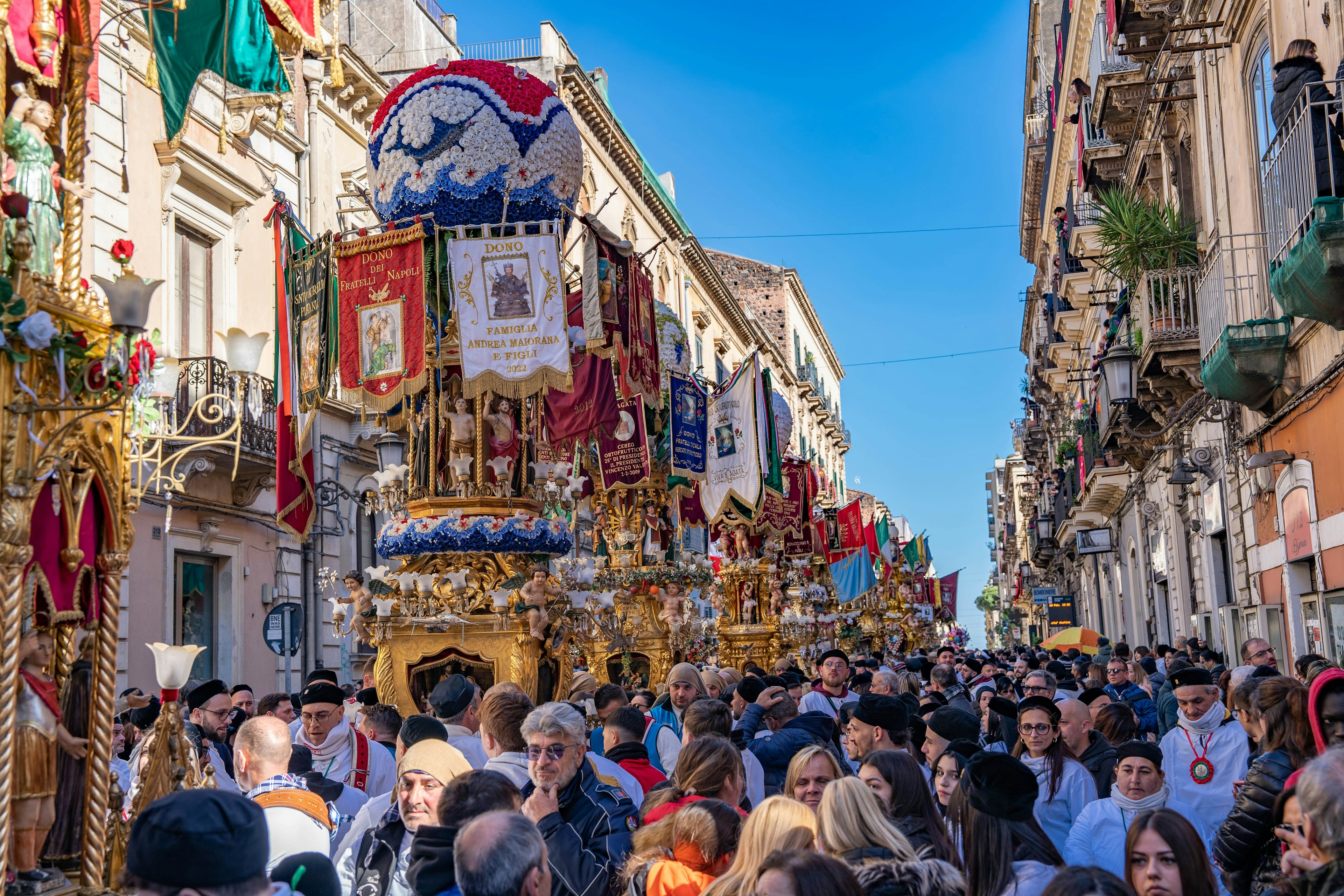 Gilded floats make their way through a crowd in Sicily for the Feast of Saint Agata