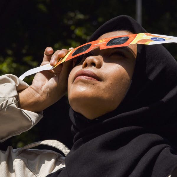 Woman using glasses to look at a solar eclipse