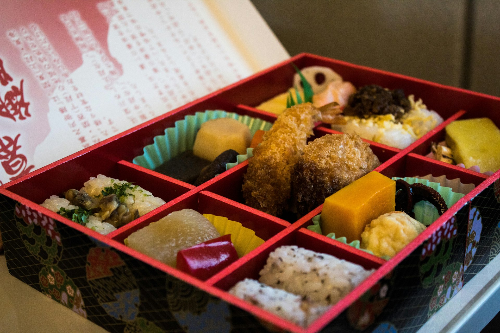 A beautifully presented box of food with each element separated into its own square