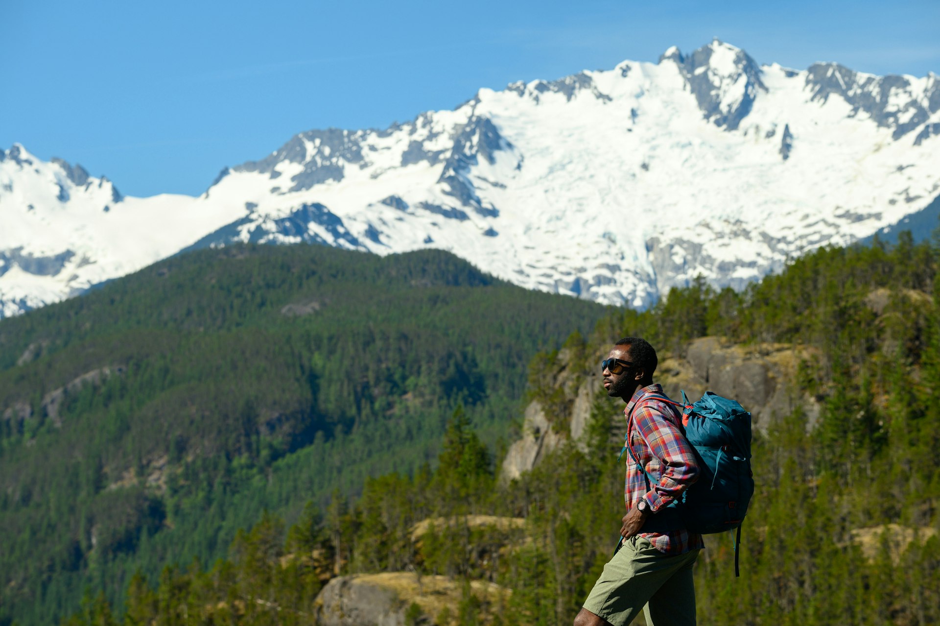 A male hiker looking away while standing against mountains, Canada